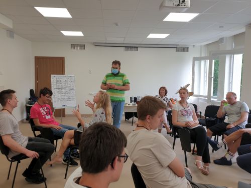 Dalyviai, susiskirstę grupelėmis, klausosi K. Bartoševičiaus paskaitos