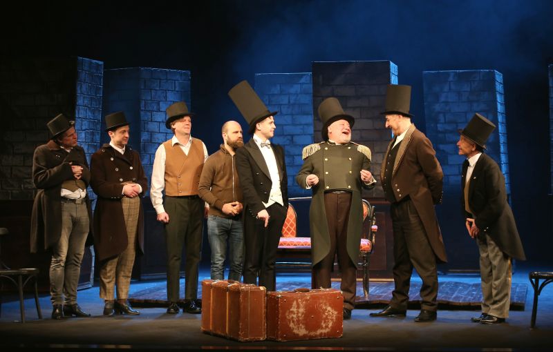 Nuotraukoje - scena i&scaron; spektaklio REVIZORIUS: grupė įvairių vyrų bendrauja tarpusavyje.