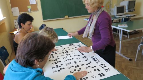 Nuotraukoje - Centro specialistė moko projekto dalyvius Brailio abėcėlės