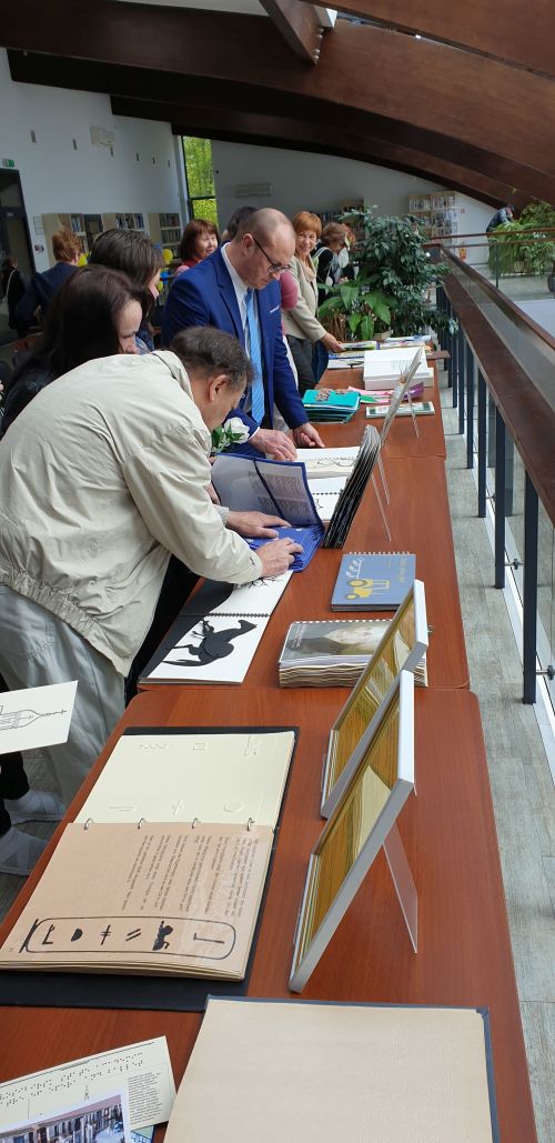 Nuotraukoje - bibliotekos lankytojai apžiūri taktilines knygas