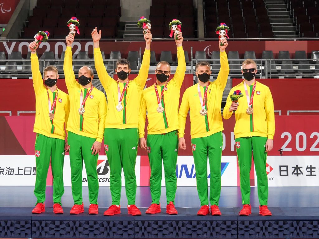 Nuotraukoje - Lietuvos golbolo rinktinė. Žaidėjai pasipuošę bronzos medaliais, laiko rankose puokštes. 